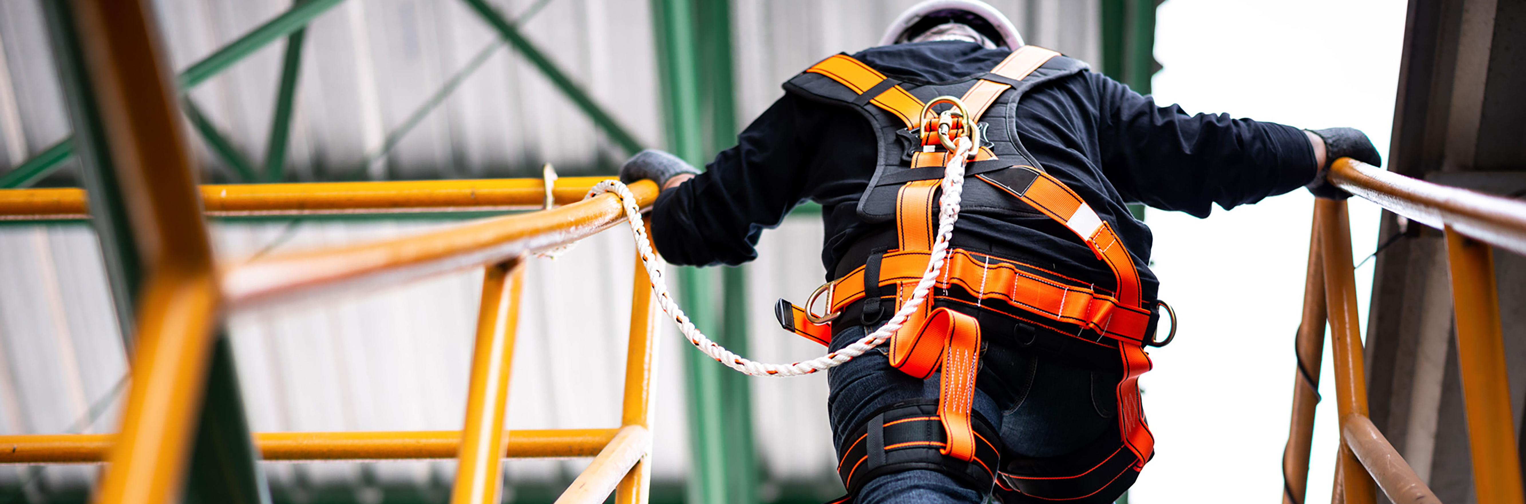 IES construction worker wearing safety harness and safety line working at a high location